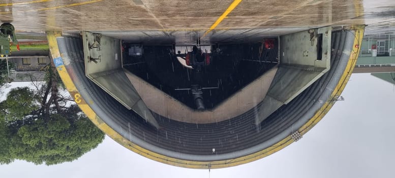 Combat aircraft parked inside an armored shelter, poised for takeoff to defend NATO skies, even on a day of heavy rain. Readiness and resilience. F-4 Phantom of Turkish Air Force. Copy Space.