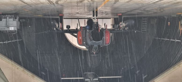 Combat aircraft parked inside an armored shelter, poised for takeoff to defend NATO skies, even on a day of heavy rain. Readiness and resilience. F-4 Phantom of Turkish Air Force. Copy Space.