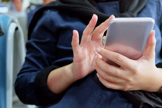 Close-up of a woman's hands holding and using a smartphone