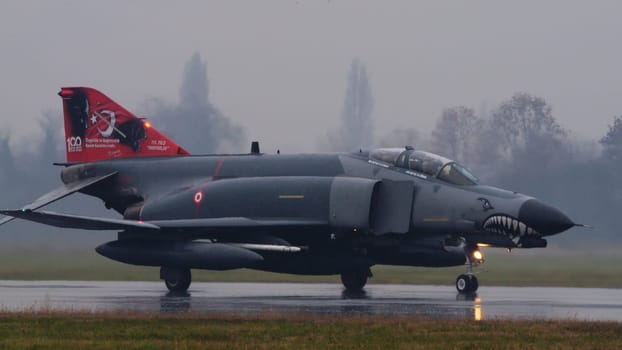 NATO fighter jets taxiing to takeoff under intense rain. highlighting the alliance readiness and the dramatic weather. McDonnell Douglas F-4 Phantom II of Turkish Air Force. Copy space.