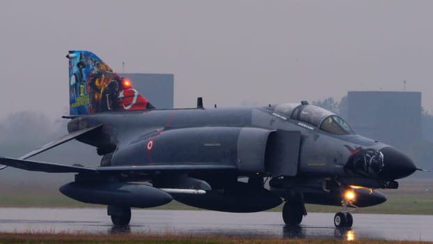 NATO fighter jets taxiing to takeoff under intense rain. highlighting the alliance readiness and the dramatic weather. McDonnell Douglas F-4 Phantom II of Turkish Air Force. Copy space.