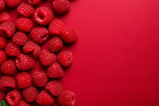 Raspberries arranged on a bright red background.