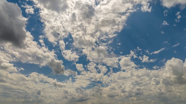 Expansive View Of A Blue Sky Filled With White Cumulus Clouds Casting Shadows On Each Other Under The Sunlight.