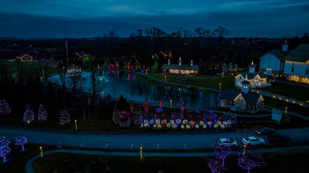 Twilight Hues Overlook A Serene Park With A Pond Surrounded By Trees And Structures Decorated With Festive Lights, Casting Reflections On The Water.