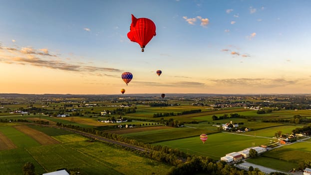 Bird in Hand, Pennsylvania, September 14, 2023 - An Aerial View of Hot Air Balloons Floating Away One is a Pigs Head, in Rural Pennsylvania at Sunrise on a Sunny Summer Morning