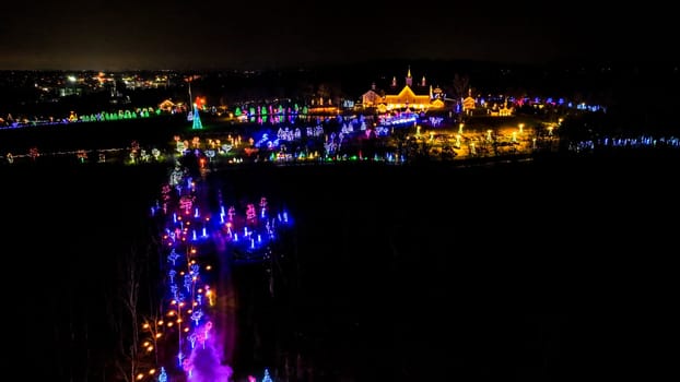 Aerial View Of A Festive Night Scene With A Trail Of Purple Smoke Leading To A Brightly Lit Castle Surrounded By Colorful Trees.