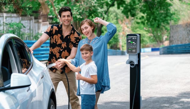 Family road trip vacation with electric vehicle, lovely family recharge EV car with green and clean energy. Natural and eco friendly car travel for sustainable environment. Perpetual