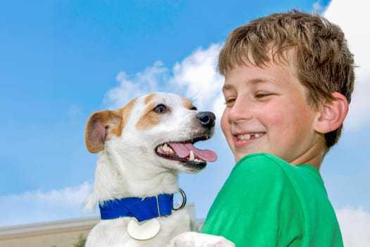 A boy holds his favorite dog in his arms
