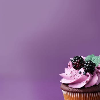 Vanilla cupcake with purple frosting and blackberries on a purple background.