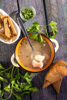 A delightful bowl of fish soup with a rich broth, fresh vegetables, and aromatic herbs, accompanied by a side of crusty bread. Ideal for a wholesome and satisfying meal, perfect for any occasion.