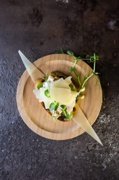 A delicious open-faced sandwich with tender chicken, melted cheese, flavorful pesto, and fresh microgreens on a wooden plate. Perfect for a quick and satisfying lunch or dinner.