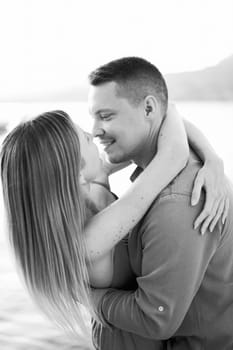 Man almost kisses woman bending her back by the sea. Black and white photo. High quality photo