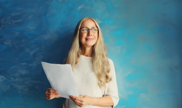 Professional caucasian middle aged woman employee in eyeglasses while working with paper document at home or office