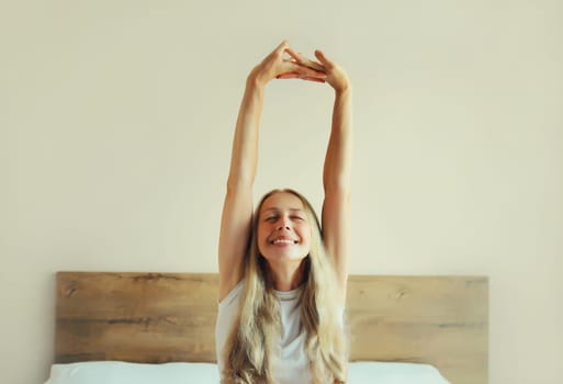 Healthy sleep, relaxed middle aged woman wakes up lying on the bed in bedroom at home