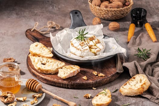 Brie type of cheese. Camembert cheese. Fresh sliced Brie cheese on a wooden tray with nuts, honey and leaves. Italian, French cheese.