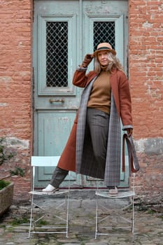 Woman in terracotta coat and leather gloves