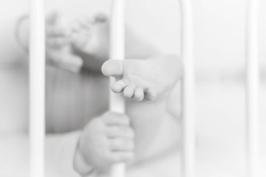 Feet and heels of a four months old baby lying on the bed at home