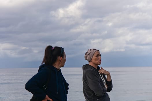 portrait of two women on the shores of the Mediterranean sea in winter 1