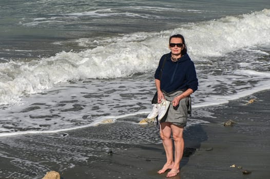 woman walks barefoot along the Mediterranean Sea in Cyprus in winter 2023 3