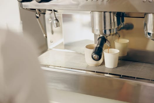 Coffee machine filling a two cups with espresso in professional coffee shop. High quality photo