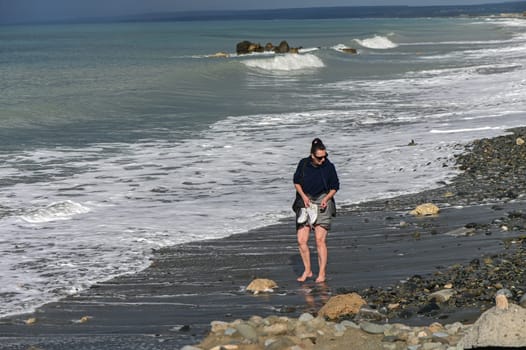 woman walking barefoot on the beach of the Mediterranean Sea in Cyprus in winter 7