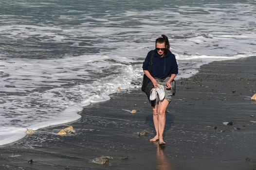 woman walking barefoot on the beach of the Mediterranean Sea in Cyprus in winter 6