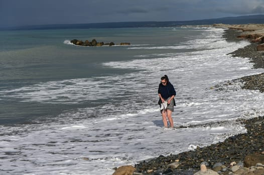 woman walking barefoot on the beach of the Mediterranean Sea in Cyprus in winter 4