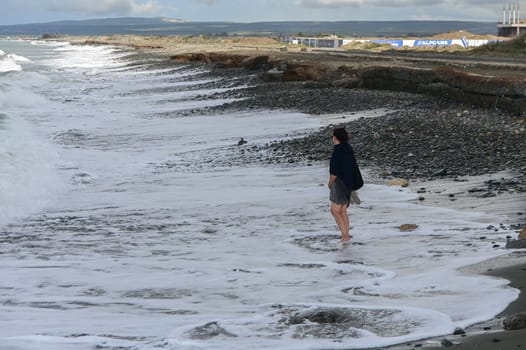 woman walking barefoot on the beach of the Mediterranean Sea in Cyprus in winter 3