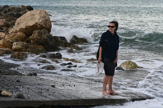 woman walks along the Mediterranean coast in Cyprus in winter 2023 2