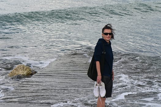 woman walks on the waves of the Mediterranean Sea in Cyprus in winter 2023 3