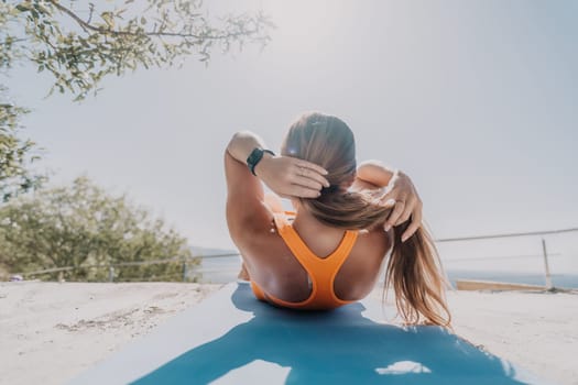 Fitness woman sea. Outdoor workout on yoga mat in park near to ocean beach. Female fitness pilates yoga routine concept. Healthy lifestyle. Happy fit woman exercising with rubber band in park.