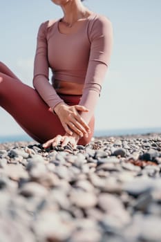 Young woman with long hair in white swimsuit and boho style braclets practicing outdoors on yoga mat by the sea on a sunset. Women's yoga fitness routine. Healthy lifestyle, harmony and meditation