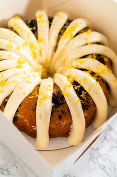 The freshly baked bundt cakes are carefully nestled into white paper boxes, preparing them for secure transportation while maintaining their delectable appearance.