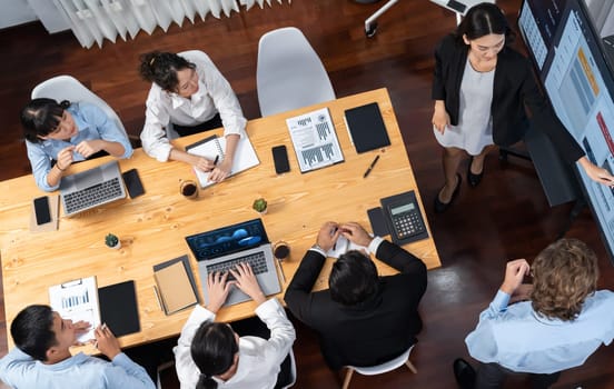 Panorama top view diverse group of business analyst team analyzing financial data report paper on meeting table. Chart and graph dashboard by business intelligence analysis. Meticulous