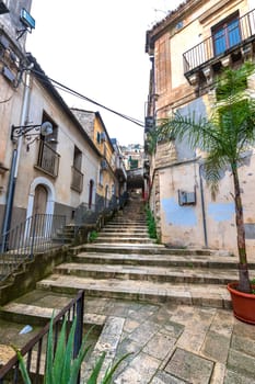 Small stone street with stairs in the Ragusa Ibla city in Sicily, Italy