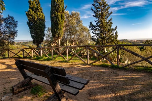 wooden bench near the beautiful tree for rest in the valley of temples, Agrigento, Sicily