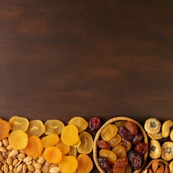 Assortment of dried fruits and nuts on wooden background.