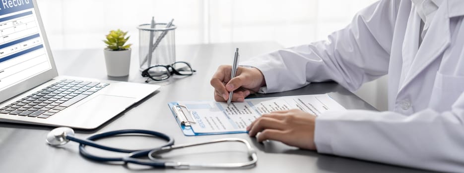 Doctor carefully review detailed medical report with laptop and diagnosing illness for effective healthcare treatment plan for patient in doctor office. Professional medical evaluation. Neoteric