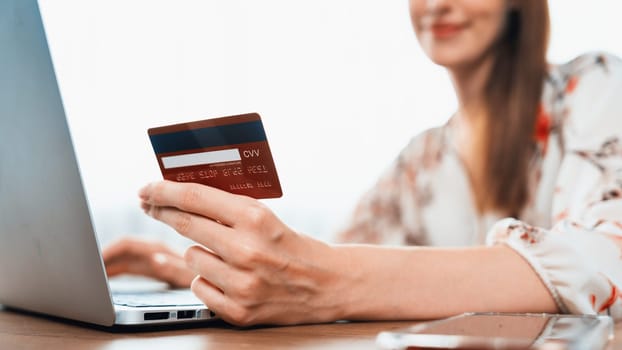 Close up credit card using for online payment, banking and shopping on the internet network with laptop computer showing credit card technology for online secured wallet top up and utmost purchase