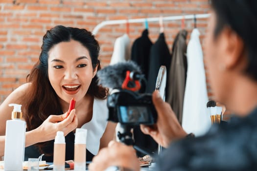 Woman influencer shoot live streaming vlog video review makeup uttermost social media or blog. Happy young girl with cosmetics studio lighting for marketing recording session broadcasting online.