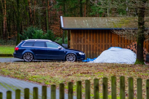 The car is parked near a wooden garage. Germany. High quality photo