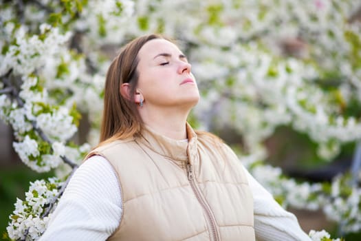 Woman in peaceful relaxation among springtime cherry blossoms