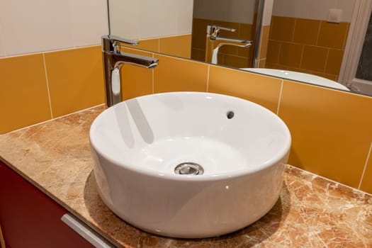 Contemporary bathroom featuring a circular vessel sink atop a marble counter