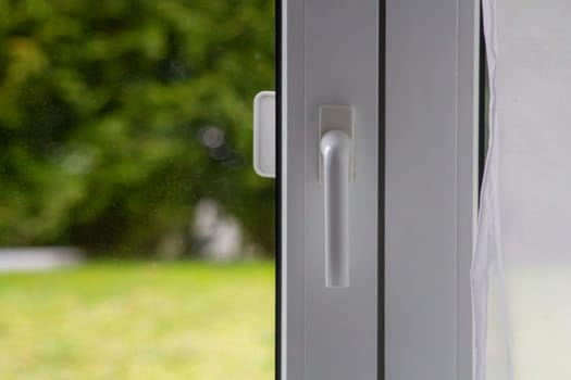 Metal-plastic window with a white handle and curtain.High quality photo