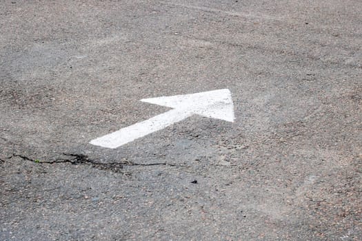 A white arrow is drawn on the asphalt close up