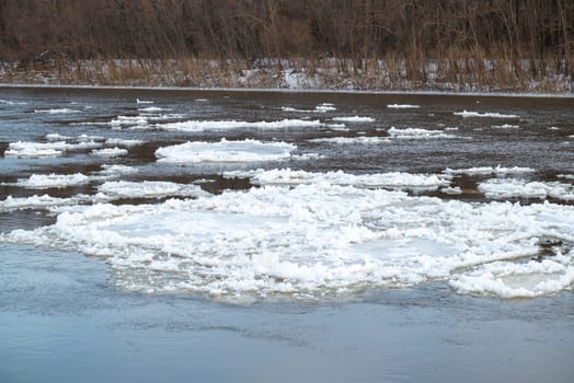 Big river covering in ice floating on the surface