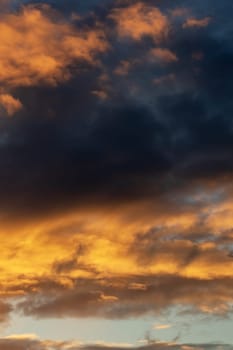 Bright yellow clouds at sunset in sky close up