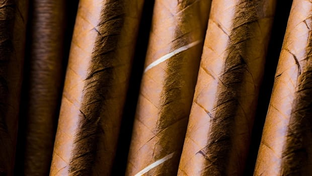 Detail of cigars with brown tobacco cover and white stripes. Generative AI.