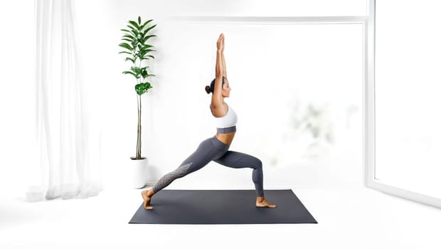 Woman practicing Yoga inside her house. Female Yoga, physical and spiritual practice with warrior posture. Generative AI.