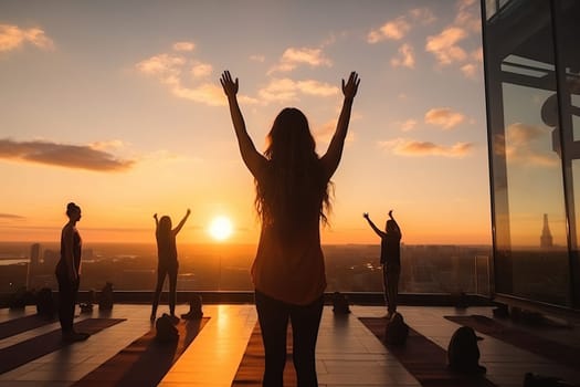 Group yoga class on the roof of a building in the sunset.